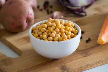Ingredients for vegetable soup. Ingredients for pea soup: potatoes, carrots, onions, garlic, peppers and peas on a wooden board. Rustic style.