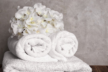Obraz na płótnie Canvas White soft towels with flowers on table