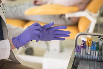 A Doctor Putting Gloves on Hands