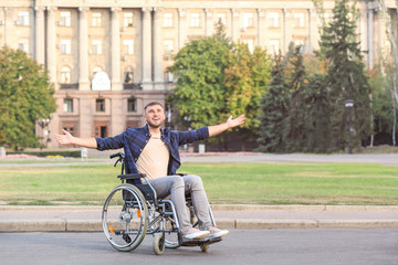 Happy young man in wheelchair outdoors