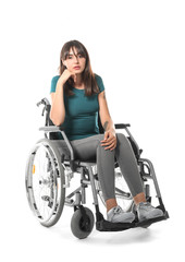 Young woman in wheelchair on white background