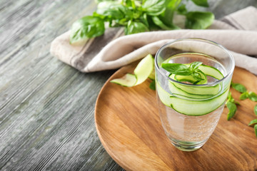 Glass of cucumber infused water on wooden table