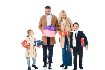 stylish family and kids in beige coats holding gift boxes, isolated on white