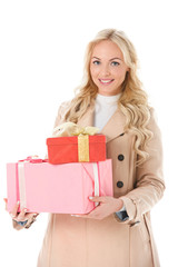 happy woman in beige autumn coat holding presents, isolated on white