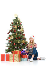 beautiful woman putting gift boxes under christmas tree, isolated on white