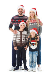 happy family with kids posing in christmas sweaters and santa hats, isolated on white