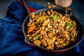 Homemade autumn pastries, pumpkin crumble pie in a cast-iron frying pan, dark blue concrete background, copy space top view