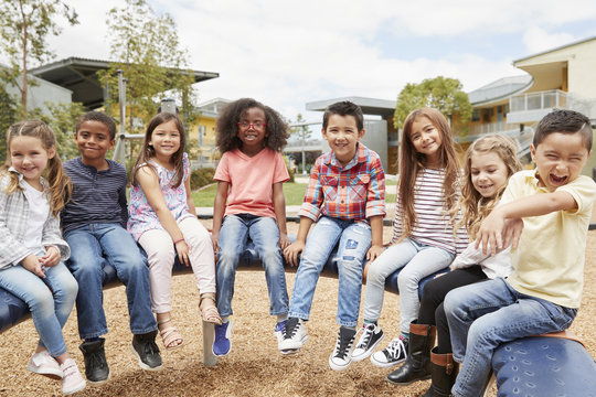 Elementary School Kids Sitting On Carousel In The Schoolyard