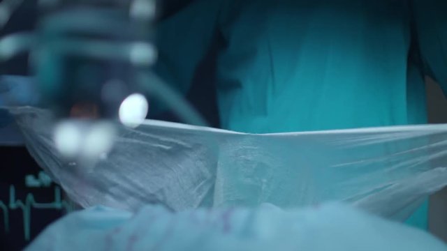 Surgeon hand tearing gauze at surgeon room. Preparing for medical operation. Medical hand tears up piece of gauze before procedure. Surgeon prepare for medical procedure