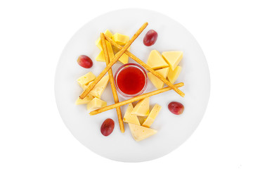 Snack to wine, sweet, a set of cheeses, jam, sweet, salty, dough sticks, grapes aperitif before alcohol, food on plate, white isolated background view from above. For the menu, restaurant, bar, cafe