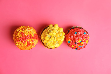Delicious colorful cupcakes on color background
