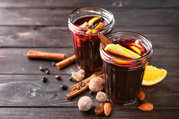 Jars of delicious mulled wine on wooden table