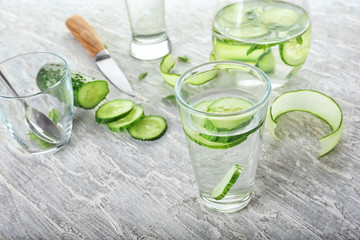 Glass of fresh cucumber water on light table
