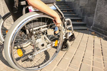 Fototapeta na wymiar Teenage girl in wheelchair near stairs outdoors