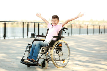 Happy boy in wheelchair outdoors