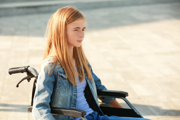 Fototapeta na wymiar Teenage girl in wheelchair outdoors
