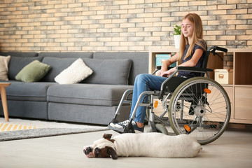 Teenage girl in wheelchair and her dog at home