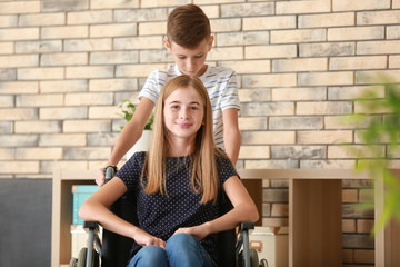 Fototapeta na wymiar Teenage girl in wheelchair and her brother at home