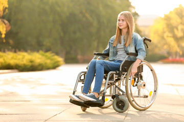 Cute teenage girl in wheelchair outdoors