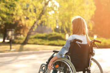 Cute teenage girl in wheelchair outdoors