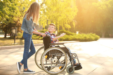 Boy in wheelchair and his sister outdoors