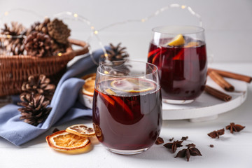 Glasses of delicious hot mulled wine on light table