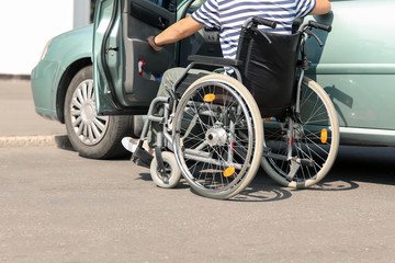 Handicapped man getting into his car