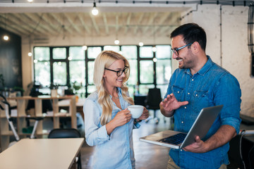 Casual business partners working on a project in modern office.