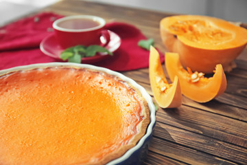 Baking dish with tasty pumpkin pie on wooden table, closeup