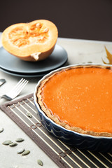 Naklejka na ściany i meble Baking dish with tasty pumpkin pie on table