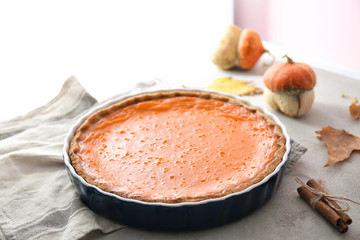 Baking dish with tasty pumpkin pie on table