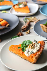 Plates with pieces of tasty pumpkin pie on table