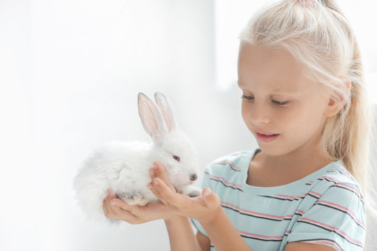 Little girl with cute rabbit at home
