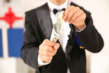 Cute little magician showing trick with money indoors, closeup