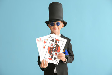 Cute little magician with cards on color background - obrazy, fototapety, plakaty