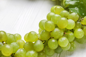 Ripe sweet grapes on white wooden table, closeup