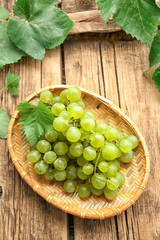 Plate with sweet grapes on wooden table