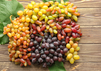 Different ripe sweet grapes on wooden table