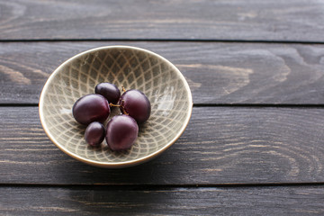 Plate with sweet grapes on wooden table