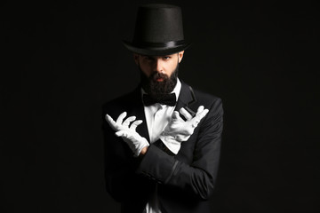 Male magician on dark background