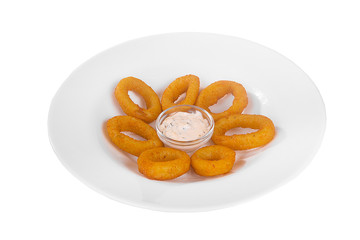 Hot appetizer onion rings in crispy golden breadcrumbs, fried in oil, mayonnaise sauce, tar-tar, 7 pieces, before alcohol, on plate, white isolated background Side view. For the menu, restaurant, cafe