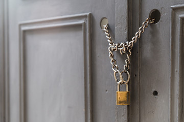 A front view of a door locked with chains and a padlock. Building and security as a concept