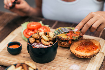 Female person eating delicious fast food. Close-up.