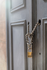 A front view of a door locked with chains and a padlock. Building and security as a concept