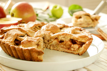 Traditional American Thanks Giving pie, whole & halved apples, cinnamon sticks, anise seeds. Homemade fruit tart baked to golden crust with ingredients. Close up, copy space, top view, background.