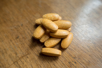 Vitamins nutritional supplement pills on wooden table