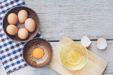 Egg yolk in wooden bowl on wood background