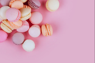 Sweet macaroons with vintage pastel colored tone on pink background.