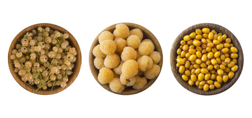 Yellow berries isolated on white background. Collage of different yellow berries. Yellow currants, yellow raspberries and sea buckthorn. Top view