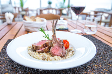 Roasted lamb chops with chanterelles and vegetables on decorated table